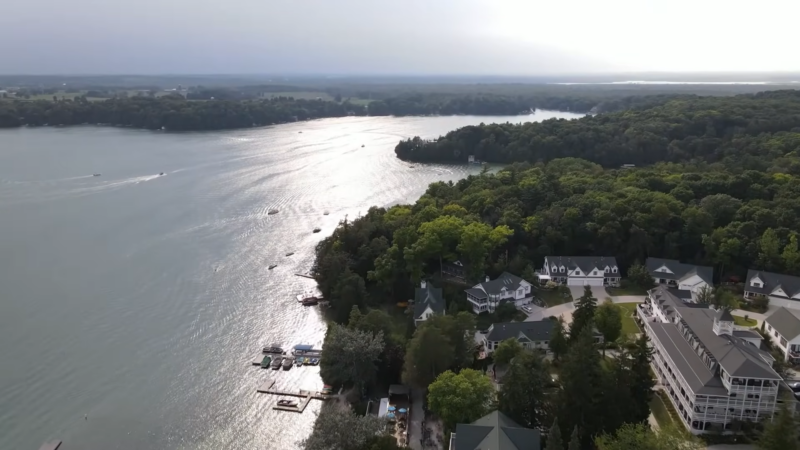 A View of Elkhart Lake in Wisconsin with Boats on The Water and Lakeside Homes Surrounded by Lush Greenery