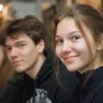 A group of students sitting together, smiling and engaged in a classroom or workshop setting